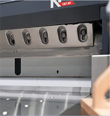 Close-up of an industrial shear cutting machine with multiple blades and safety components